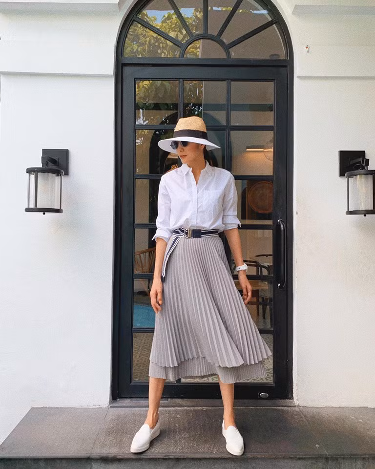 Áo sơ mi với chân váy xếp li là một sự kết hợp tưởng như đơn giản nhưng lại gây được ấn tượng của Hà Tăng.