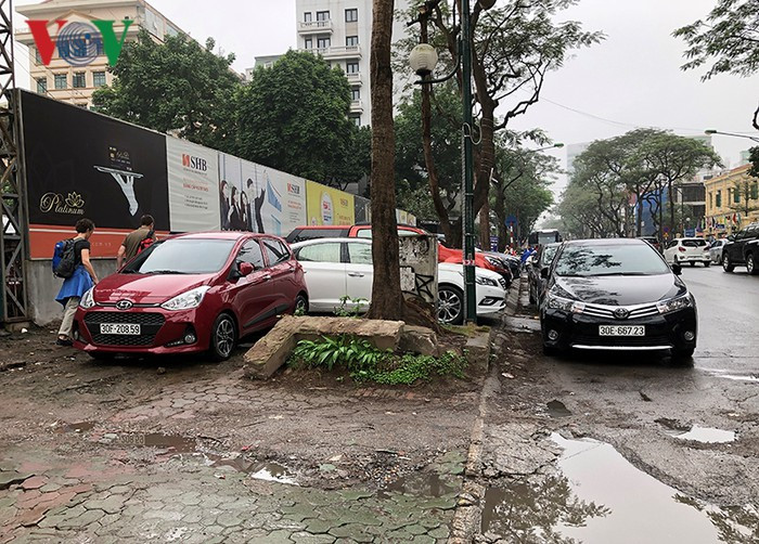 Ô tô dừng đỗ dưới lòng đường và cả vỉa hè cản trở giao thông và người đi bộ.