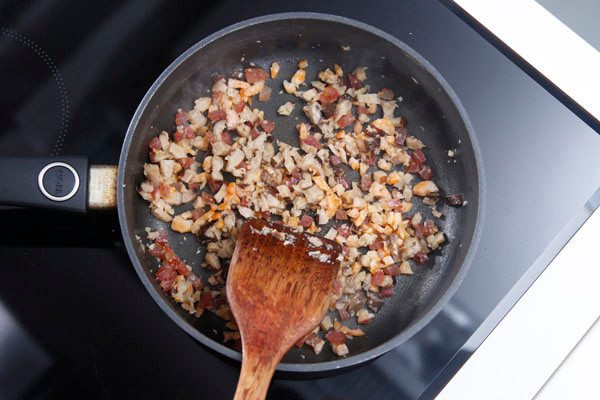 Làm nóng chảo ở nhiệt độ cao, phi tỏi thơm sau đó cho tôm, nấm và lạp xưởng vào xào. Cho gạo nếp và 100ml nước dùng gà vào chảo, đảo qua để tôm, nấm, lạp xưởng lẫn đều vào gạo, đậy nắp nấu khoảng 5 phút để gạo hấp thụ hết nước dùng.