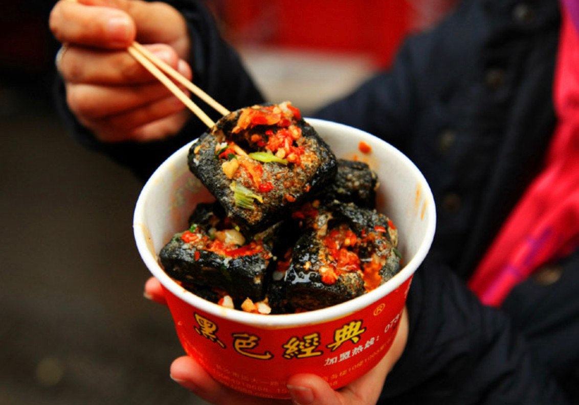 Đậu phụ thối: Phượng Hoàng Cổ Trấn thuộc tỉnh Hồ Nam, nơi rất nổi tiếng với món đậu phụ thối hỏa cung điện. Món đậu phụ thối bình thường chỉ ngâm trong nước muối 5-10 ngày, còn đậu phụ Hồ Nam lại được ủ đến 15 ngày. Do thời gian ủ dài hơn mà món đậu phụ thối này trở nên thơm bùi và béo ngậy hơn.