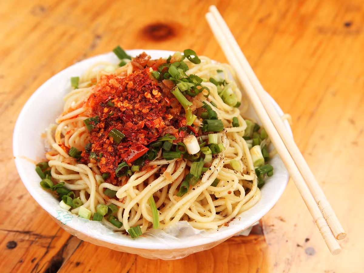 Mì Dan Dan ra đời từ năm 1841, do một người bán hàng rong có tên là Trần Bảo Bảo sáng tạo nên. Từ “Dan Dan” trong ngôn ngữ địa phương dùng để chỉ đòn gánh của những gánh hàng rong, chính thế, món ăn này còn được gọi là mì gánh.