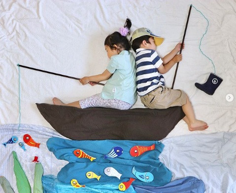 Hai đứa cùng ngồi câu cá trên thuyền.