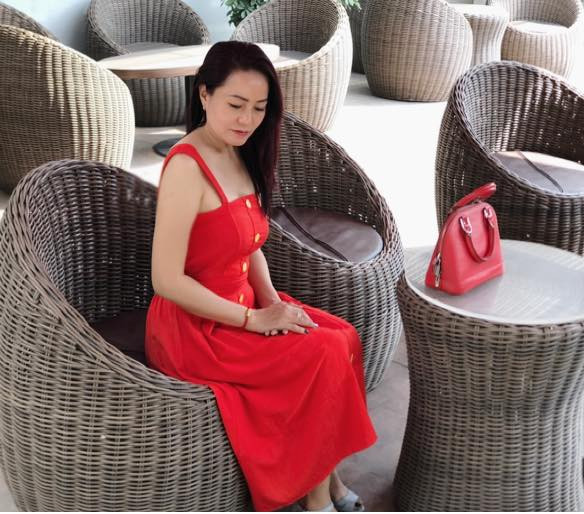 Chị diện váy đỏ hai dây sành điệu phối với túi xách cùng tông. Ảnh: FBNV.