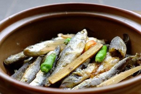 Đầu cá kho với mía đầu cá sẽ rất mềm, có thể ăn được. Cây mía, róc bỏ vỏ, chẻ nhỏ để dưới đáy nồi, rồi cho cá, nước dừa xiêm vào ngập xâm xấp, để lên bếp đun với ngọn lửa riu riu cho đến khi nước dừa rút cạn, cá chín, xương mềm rục là được. Cuối cùng, người ta cho thêm vào một ít tiêu xay, vài trái ớt hiểm chín để hoàn thành món ăn. Ảnh: Internet.