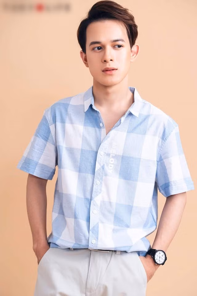 Quang Anh mặc áo sơ mi kẻ karo phối với quần âu cũng đầy lịch lãm.
