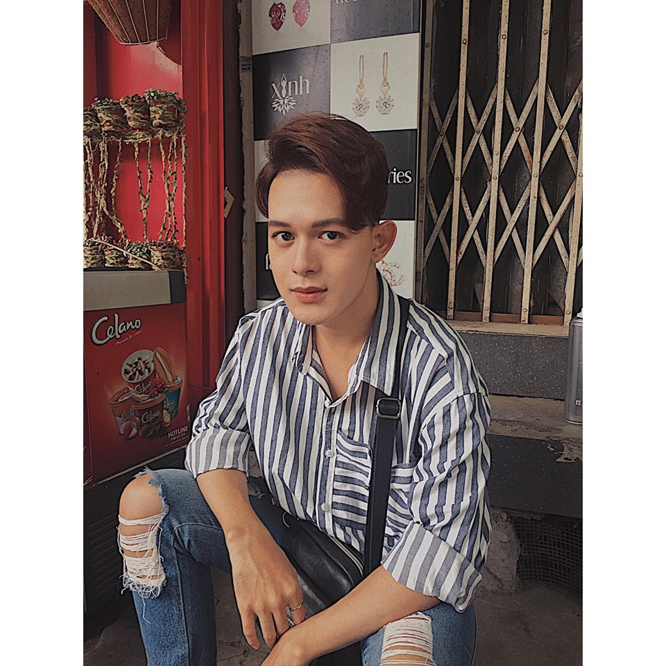 Anh phối áo sơ mi kẻ với quần jean rách cá tính.