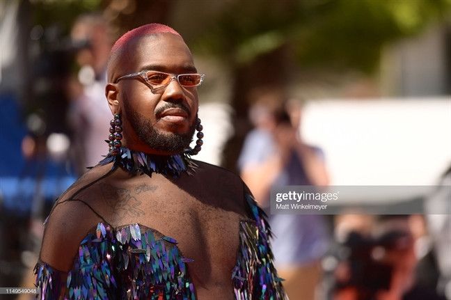 Thậm chí, nam DJ còn nhuộm tóc hồng, mang hoa tai xâu chuỗi to bản để nhấn nhá thêm cho bộ trang phục cực dị.