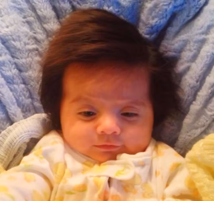 Em bé 2 tháng tuổi có mái tóc đẹp tự nhiên.