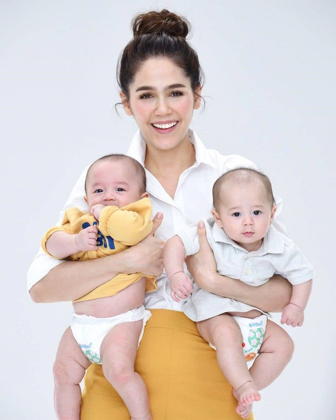 Bà mẹ hai con diện áo sơ mi trắng và chân váy vàng vô cùng trẻ trung. Ảnh: Internet.