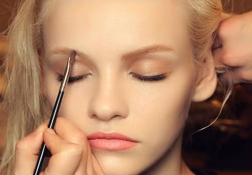 Để trông thật tự nhiên, bạn hãy dùng một chút màu mắt nâu nhẹ nhàng tán mỏng lên vùng mí mắt và hốc mắt. Sau đó, bạn có thể tạo điểm nhấn với một chút nhũ mắt màu sáng.