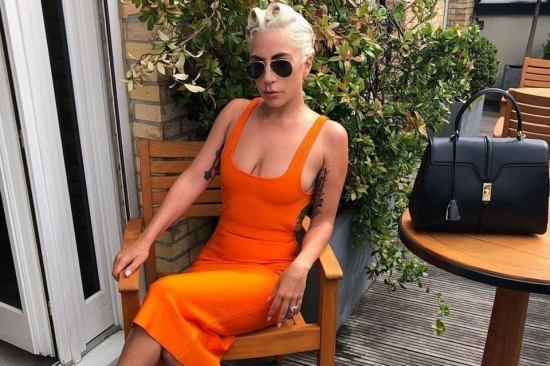 Chiếc váy màu cam ôm sát khoe khéo vòng một căng tròn của Lady Gaga.
