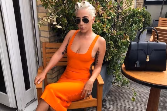 Chiếc váy màu cam ôm sát khoe khéo vòng một căng tròn của Lady Gaga.