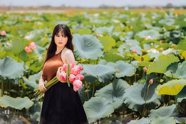 Thu Trang trông cực kỳ quyến rũ khi mặc áo yếm chụp ảnh bên đầm sen.