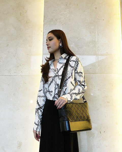 Áo sơ mi họa tiết dây xích phối với chân váy dài vừa thanh lịch vừa sang trọng.