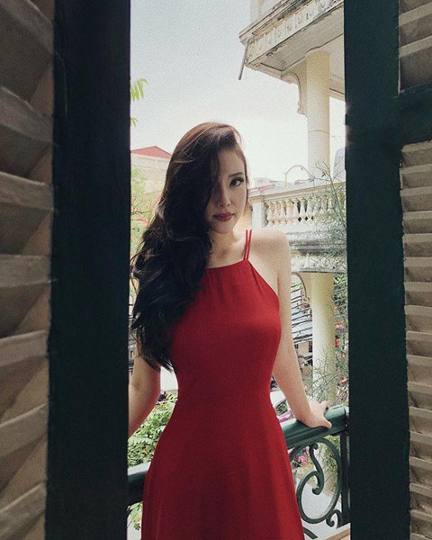 Ngọc Phượng diện váy đỏ cổ yếm với mái tóc gợn sóng buông sang một bên đầy quyến rũ.