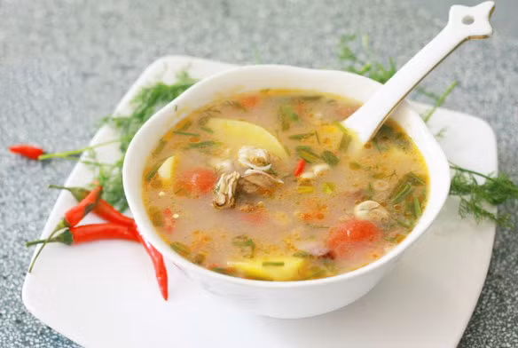 Cách làm: Hàu làm sạch và để ráo, hành thái khúc, cà chua thái nhỏ, dứa thái miếng vừa ăn. Đặt nồi lên bếp, phi hỗn hợp hành và dầu ăn nóng và thơm. Cho cà chua vào đảo cho chín mềm. Dứa và hàu cho vào xào sơ qua rồi nêm nếm chút mắm, muối, hạt nêm. Cho sấu hoặc me đập dập vào tăng vị chua. Thêm nước đun sôi chín tới nêm nếm vừa ăn. Cuối cùng thêm rau thơm, rau răm hành lá tùy sở thích.