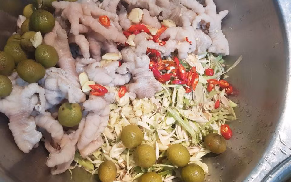 Chân gà sấu mắm chua ngọt có thể coi là phiên bản cập nhật mùa hè của món chân gà sả tắc nức tiếng. Sấu vào mùa dày mình, gọt rửa sạch, ngâm cho thật ngấm thứ mắm chua ngọt thơm thơm mằn mặn. Đi kèm thứ chân gà lai rai "chấm mút" thần thánh, cực hợp để "gặm nhấm" xem phim những ngày mưa.