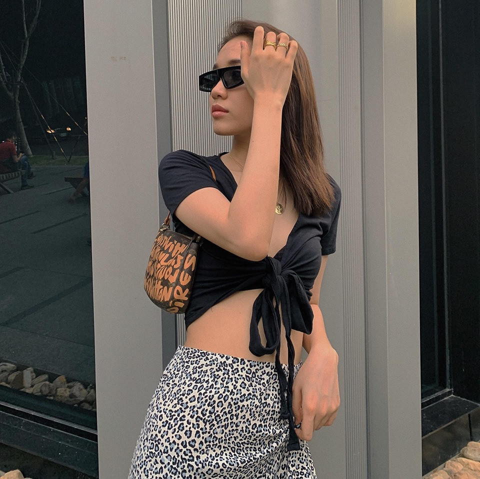 Chiếc áo thắt nơ ngực giống áo tắm được nữ diễn viên kết hợp với chân váy họa tiết da báo sành điệu.