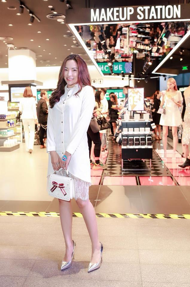 Chiếc đầm trắng chân ren được cô phối với túi xách trắng và giày màu bạc bắt mắt.