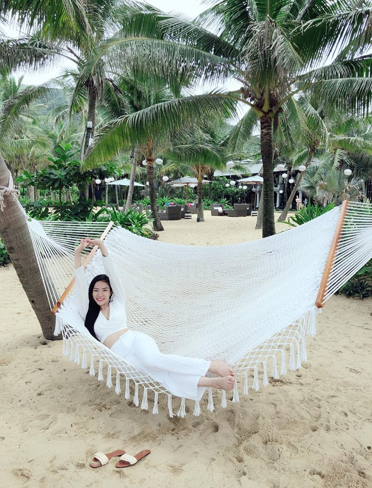 Người đẹp diện cả bộ trắng tinh khôi khoe eo thon khi đi biển.