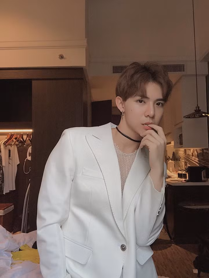 Giọng ca "Sau tất cả" trông khá nữ tính điệu đà khi diện vest trắng và mặc áo lưới bên trong.