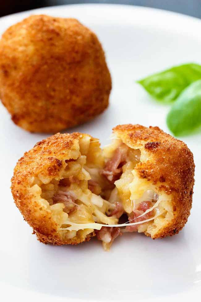 Arancini ở Ý: Tên của món ăn có nghĩa là quả cam nhỏ nhưng thực tế món ăn không liên quan gì đến cam mà vì nó có hình dạng và màu sắc gần giống quả cam. Món Arancini gồm những viên cơm được nhồi với vụn bánh mì rồi chiên giòn. Chúng thường chứa đầy thịt trong sốt cà chua, mozzarella và đậu Hà Lan.