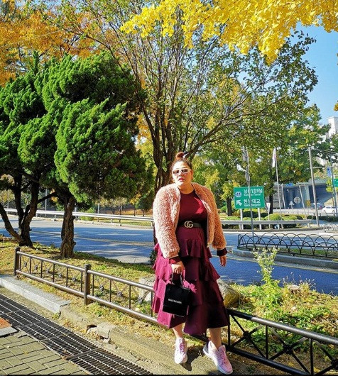 Khi đi du lịch, cô diện váy tầng màu mận phối với áo khoác lông cực sang chảnh.