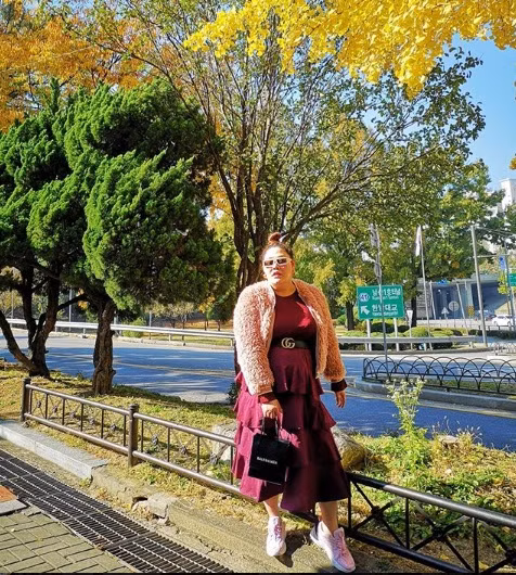 Khi đi du lịch, cô diện váy tầng màu mận phối với áo khoác lông cực sang chảnh.