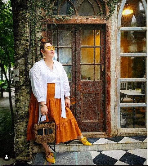 Áo sơ mi trắng phối với chân váy màu cam cực kỳ sang chảnh và trẻ trung. Ảnh: Instagram.