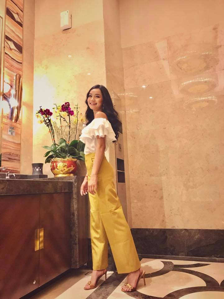 Cô nàng kết hợp áo sơ mi trễ vai với quần vàng sang chảnh.