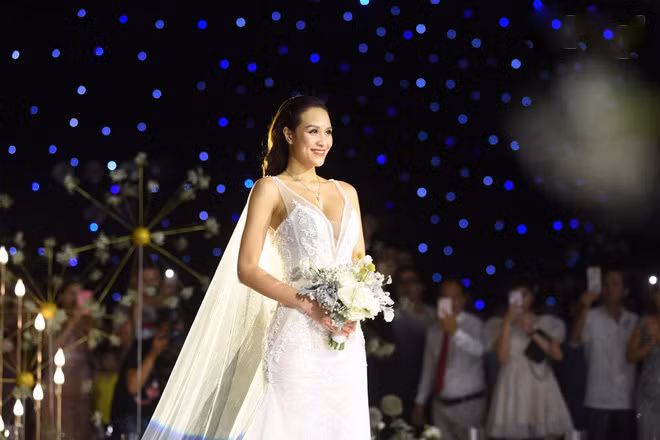 Khi làm lễ, MC Phương Mai diện váy cưới khoét sâu khoe ngực đầy. Chất liệu vải mỏng manh, xuyên thấu có thêu hoa văn mềm mại giúp nữ MC vô cùng quyến rũ.