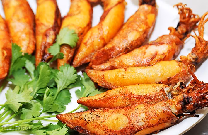 Mực sim chao dầu vàng rộm, thơm mùi gia vị, ăn kèm với tương ớt hoặc các loại rau ăn kèm sẽ khiến bạn không khỏi nức nở trước độ ngon của nó.