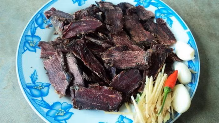 Bò gác bếp: Cao Bằng là nơi nuôi nhiều bò, tập trung nhiều nhất là các huyện Hà Quảng, Bảo Lạc, Bảo Lâm. Bò gác bếp Cao Bằng được tẩm ướp bằng các gia vị như muối, nước gừng, rượu trắng. Trước khi ướp, thịt được khía vài đường trên miếng thịt cho gia vị ngấm đều. Sau khi ướp xong dùng lạt tre tươi xâu thịt thành từng xâu rồi treo trên gác bếp. Ảnh: Tuổi Trẻ.