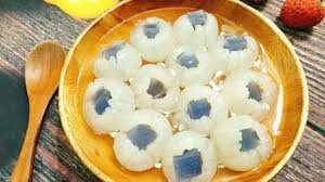 Cách làm: Nấu 150g đường cát để tạo nước, cho trái vải vào rim đường, lửa nhỏ khoảng 20 phút, bắc xuống, để nguội. Tiếp theo tiến hành hòa tan rau câu với nước dừa tươi, thêm 50g đường còn lại, cho bột hạnh nhân vào, lại đun sôi. Khi thấy rau câu sánh, nhấc xuống cho vào khuôn, để nguội.