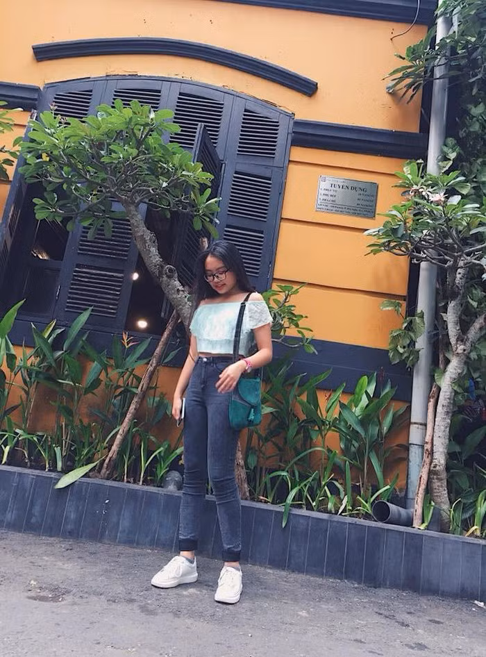 Áo croptop trễ vai được cô phối với quần jean trẻ trung, năng động nhưng không kém phần gợi cảm.