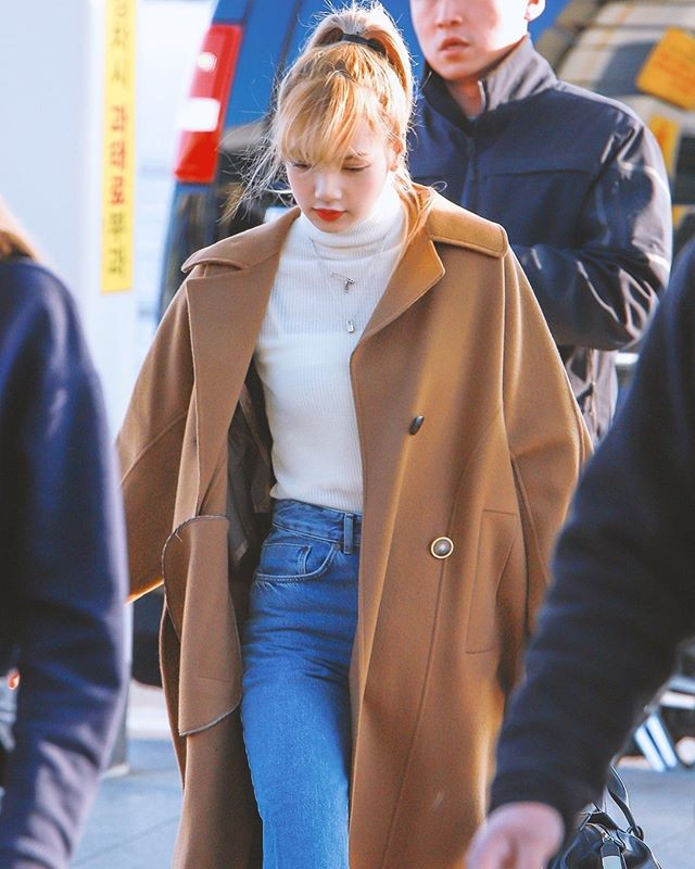 Áo khoác nâu được kết hợp khéo léo cùng áo cổ lọ trắng và quần jeans xanh tạo nên sự trẻ trung và thanh lịch.