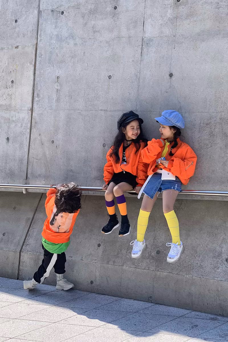 Ba em nhỏ chơi trội với màu gam đang xu hướng năm nay - cam san hô.