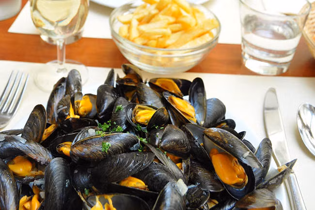 Moules-frites: Có hai loại thực phẩm bổ sung cho nhau cực kỳ tốt là trai hấp bia với khoai tây chiên ăn kèm. Và tuyệt vời hơn nữa nếu được dùng với một chút rượu vang trắng.