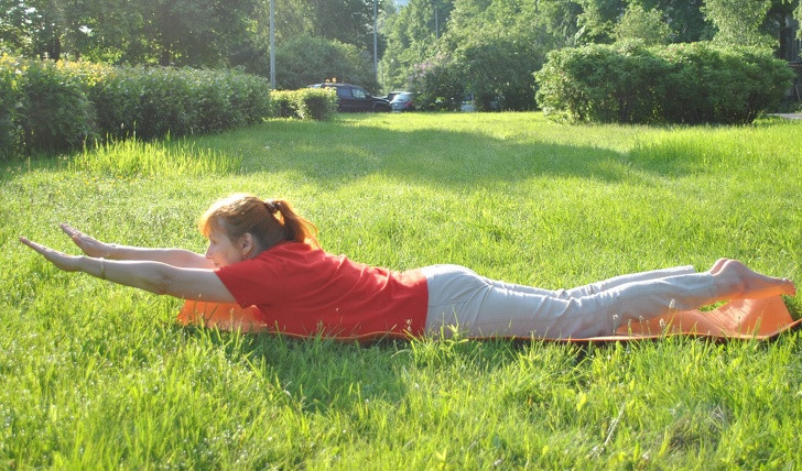 Bài tập siêu nhân: Nằm sấp trên thảm, hai tay duỗi thẳng phía trước mặt, mũi chân úp. Nâng tay, đầu, cổ, ngực và chân lên cao. Giữ trong khoảng 3 giây rồi trở lại tư thế ban đầu. Lặp lại động tác trong 30 giây. Ảnh: BS.