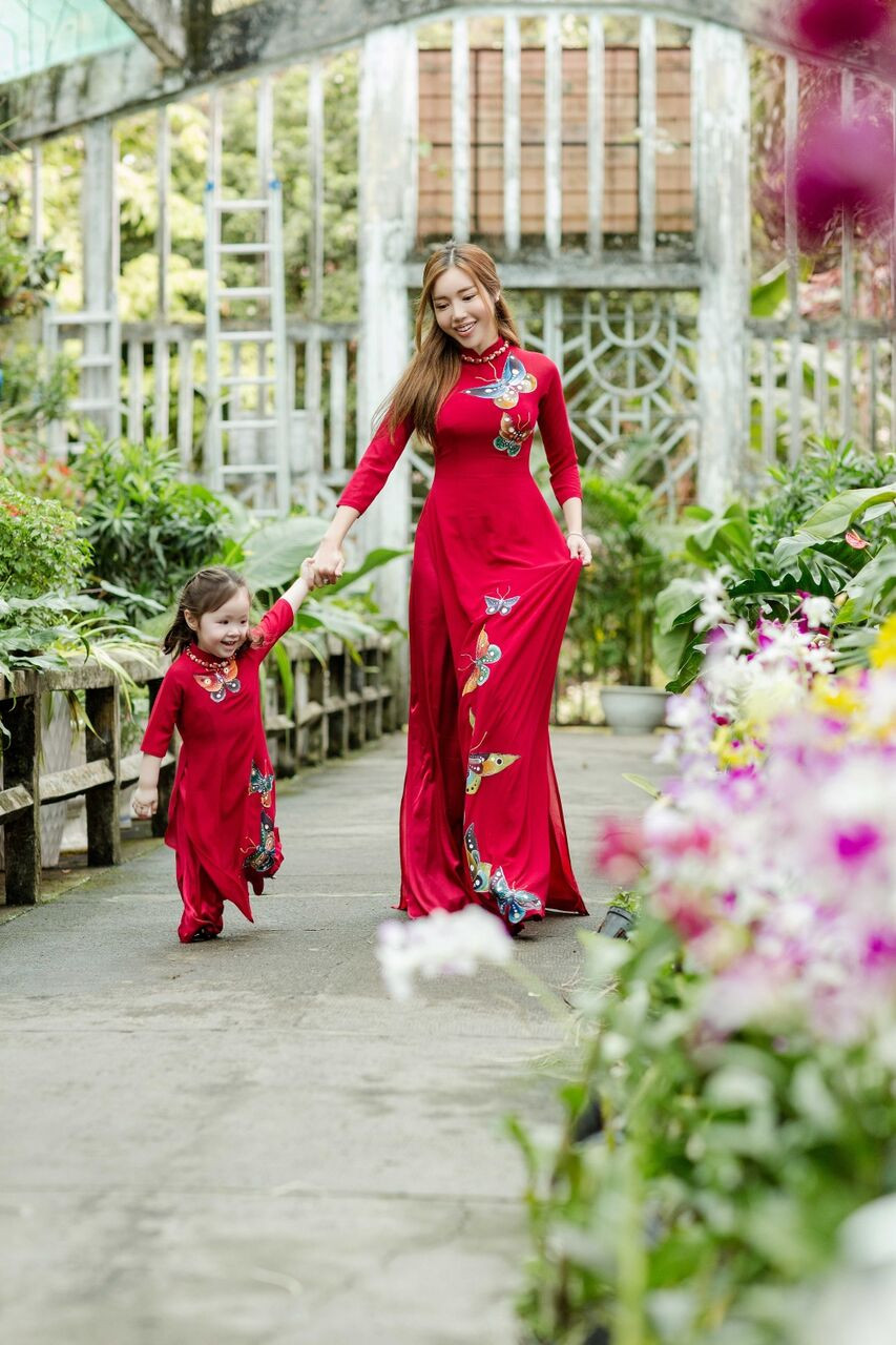 Hai mẹ con nữ diễn viên mặc áo dài đỏ nền nã. Ảnh: FBNV, Internet.