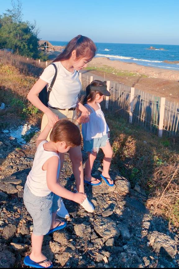 Elly Trần diện áo phông trắng cùng tông màu với trang phục của con trai và con gái trong chuyến đi biển.