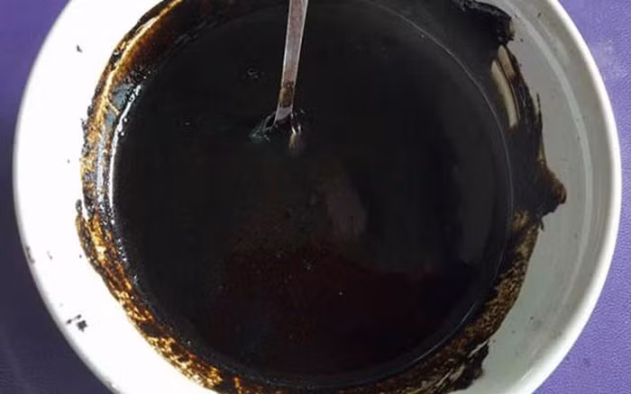 Hỗn hợp tẩy da chết cho mặt, toàn thân từ than hoạt tính: Đun chảy bơ shea rồi khuấy đều với dầu thầu dầu, dầu hạt dẻ và sữa tắm trẻ em. Đợi hỗn hợp nguội bớt thì cho thêm các loại tinh dầu và khuấy đều. Ảnh: Cooky.vn.