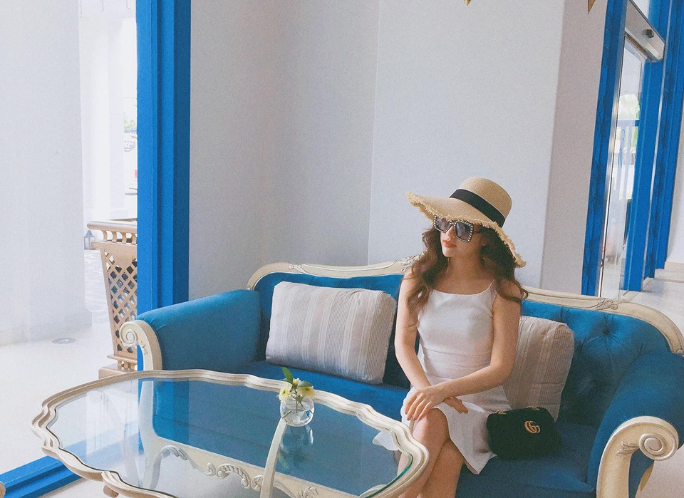 Vợ cũ của diễn viên Việt Anh phối đầm trắng với túi xách đen và mũ kính rất sang chảnh.