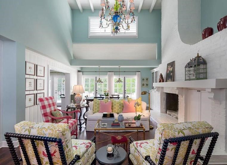 Phòng khách và một khu vực ăn uống được tích hợp trong không gian rộng lớn với nội thất sặc sỡ, lò sưởi gạch trắng và trần nhà cao.