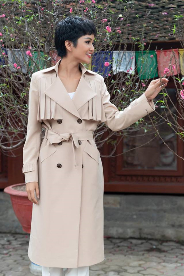 Hoa hậu H'Hen Niê thanh lịch với áo măng tô xếp nếp ngực "thả dáng" bên hoa đào.