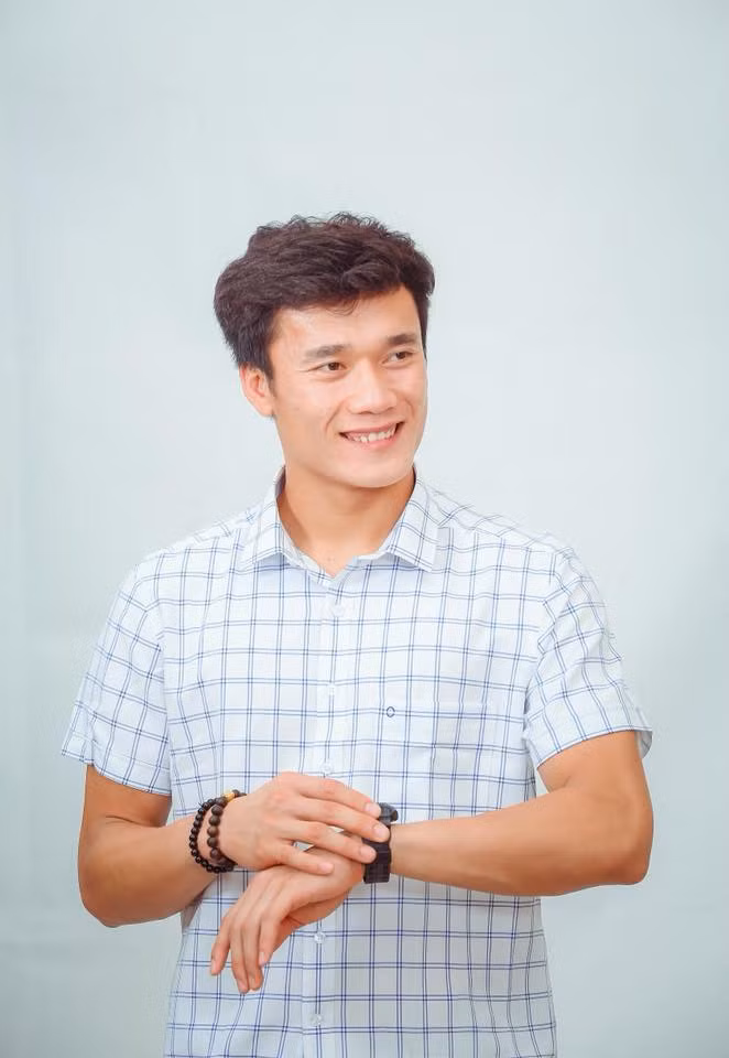 Chàng thủ môn trẻ diện chiếc áo sơ mi kẻ khỏe khoắn.