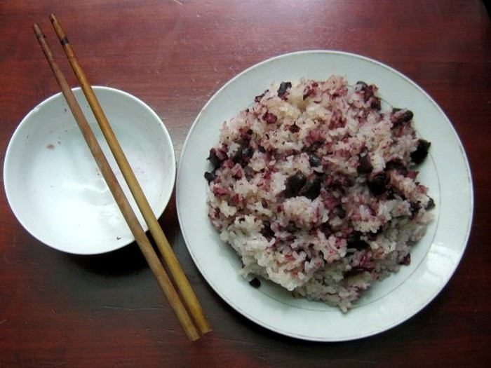 Tiếp theo, đặt chõ lên bếp, khi nước trong chõ bắt đầu sôi thì nhẹ nhàng đổ gạo vào, xếp thịt trám lên trên cùng. Khoảng 30 phút là xôi chín, nhấc ra, rưới thêm 1 thìa cà phê mỡ thăn heo rồi đùng đũa tre đánh đều sao cho trám và xôi quyện lẫn với nhau.