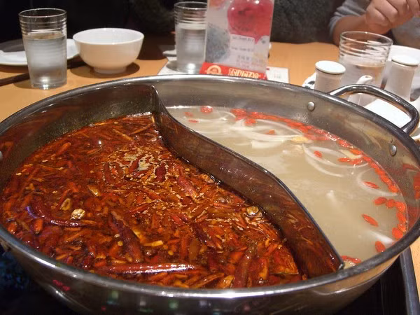 Lẩu Tứ Xuyên là một món ăn tối phổ biến: bạn ngồi xung quanh một nồi lẩu cay và nấu thức ăn của riêng mình bằng nước dùng. Nhiều nhà hàng phục vụ món lẩu nổi tiếng này, họ chia ra làm 2 phần, một bên cay, một bên không, để thực khách thoải mái lựa chọn. Ảnh: Internet.
