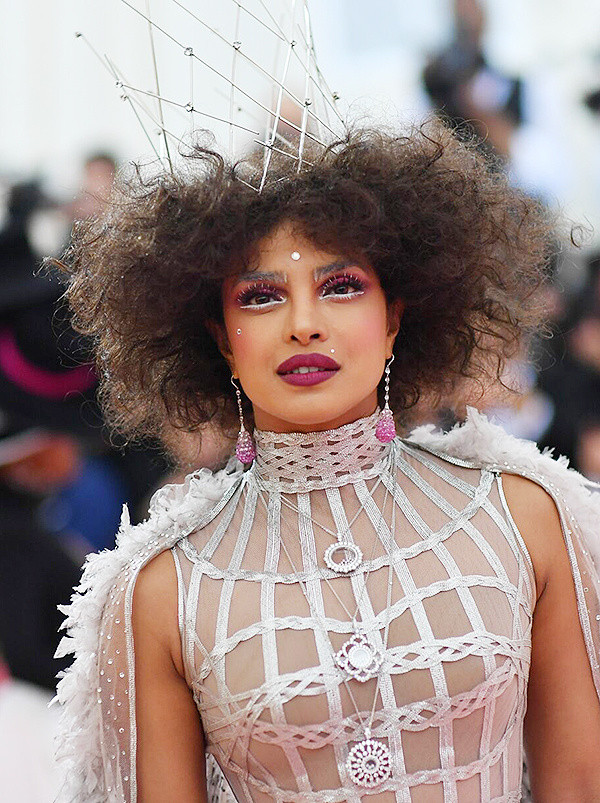 Hoa hậu Priyanka Chopra hóa nữ hoàng với sắc thái châm biếm qua kiểu trang điểm màu mè và mái tóc hình tổ quạ.