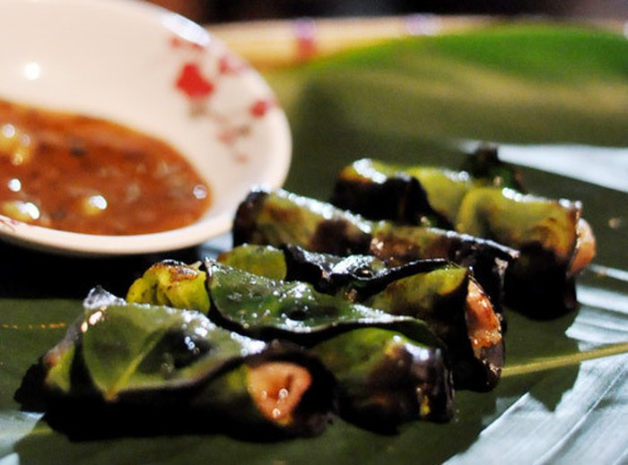 Chả cuốn lá bưởi: Món ngon hấp dẫn ở Hòa Bình này thơm nồng mùi thịt quyện với tinh dầu bưởi, đem lại một cảm giác rất lạ. Phần thịt không quá ngấy, săn, ngọt vị; còn phần lá bưởi cháy giòn giòn, thơm thơm, cắn một miếng đã thấy tê tê nơi đầu lưỡi, không cay, không đắng mà lại đem đến một cảm giác vô cùng thích thú. Ảnh: Danviet.